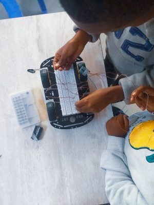 A dedicated tutor helps a young boy with his homework on a laptop, fostering learning.