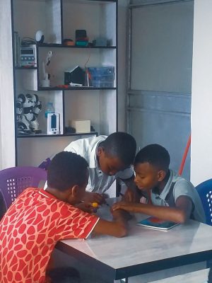 Two students working together in an engineering workshop with focus and precision.