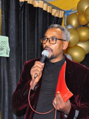 A businessman adjusting his tie in a stylish home office, preparing for an online meeting.